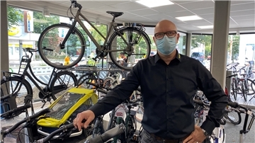Ein Fahrradhändler steht in seinem Geschäft.