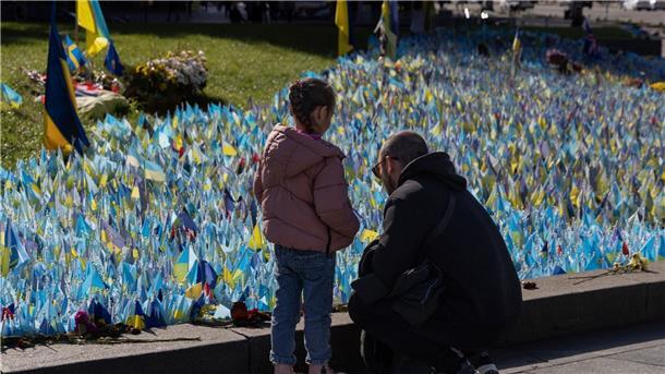 Familienmitglieder besuchen in Kiew das Denkmal für ukrainische Soldaten, die im Krieg gegen Russland gefallen sind.