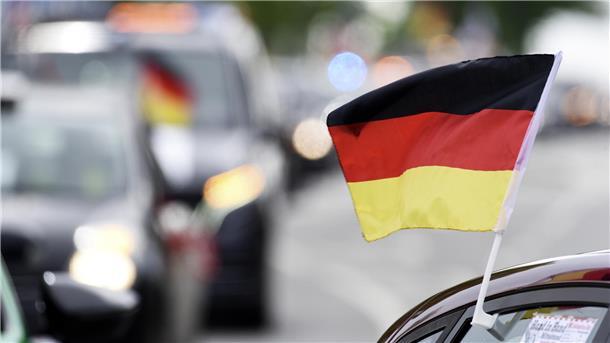 Feiernde Fußballfans auf den Straßen: Auch beim Jubeln gibt’s Spielregeln Fußballfans mit Flagge am Auto