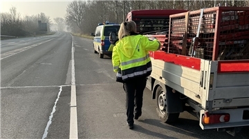 Eine Polizistin kontrolliert ein Fahrzeug während einer Verkehrskontrolle.