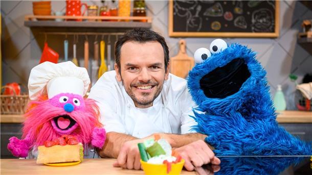 Krümelmonster: Henssler nie böse, wenn ich Zutaten esse Fernsehkoch Steffen Henssler zwischen den Puppen „Gonger“ (l) und „Krümelmonster“ am Film-Set.