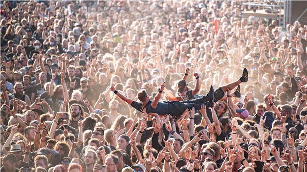 Festivalsommer 2023: Genug Personal, aber explodierte Kosten Festivalbesucher werden beim Wacken Open Air Festival beim Crowdsurfen über die Menge getragen. Das WOA gilt als größtes Heavy-Metal-Festival der Welt.