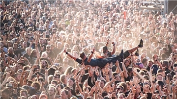 Festivalbesucher werden beim Wacken Open Air Festival beim Crowdsurfen über die Menge getragen. Das WOA gilt als größtes Heavy-Metal-Festival der Welt.