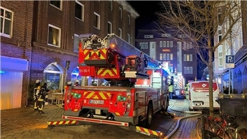 Feuerwehreinsatz im Alten Deichweg: Feuerwehrfahrzeuge sichern das Wohngebäude mit Café in Cuxhaven, während die Ermittlungen zur Rauchentwicklung fortgesetzt werden.