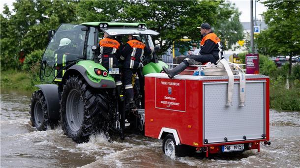 Süddeutschland ächzt unter dem Hochwasser Feuerwehrleute fahren in Reichertshofen über eine überflutete Straße.