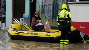 Feuerwehrleute retten eine Anwohnerin und ihren Hund im Ort Campi di Bisenzio.