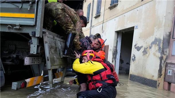 Überschwemmungen in Teilen Italiens - Neun Tote Feuerwehrleute retten einen älteren Mann in dem überfluteten Dorf Castel Bolognese.