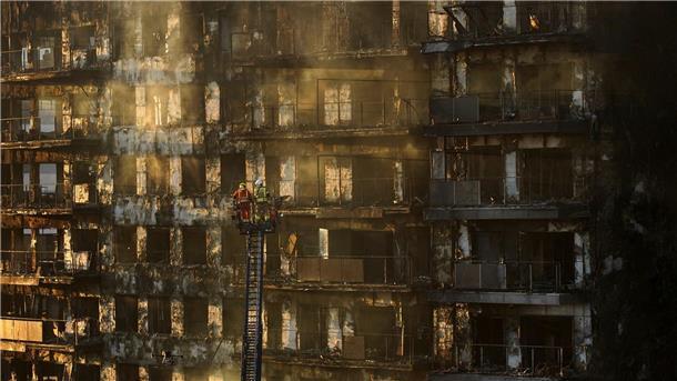 Feuerinferno mit mindestens neun Toten schockt Spanien Feuerwehrleute stehen während Löscharbeiten auf einer Hubleiter.