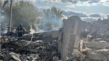 Feuerwehrleute umgeben von Trümmern im ukrainischen Dorf Hrosa. Ein russischer Raketenangriff hat hier Dutzende Menschen getötet.
