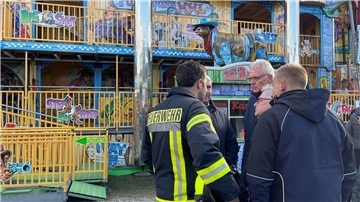 Feuerwehrleute und Polizisten stehen vor dem Funhouse auf dem Pollhansmarkt in Schloß Holte-Stukenbrock.
