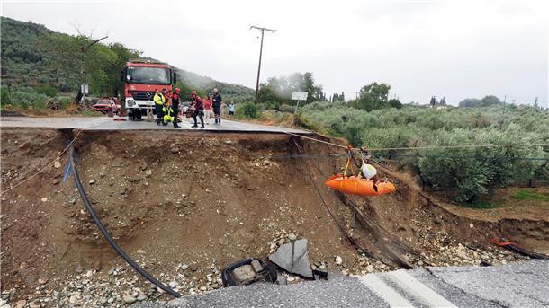 Extremwetter in Griechenland, Türkei und Bulgarien dauert an Feuerwehrleute verwenden Seile, um einen Nierenpatienten auf einer Trage über eine durch einen Regensturm beschädigte Straße zu transportieren.