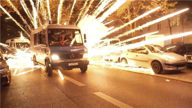Entsetzen über Brandsätze vor Synagoge - Ausschreitungen Feuerwerkskörper fliegen hinter einem Polizeiauto bei einer nicht angekündigten pro-palästinensischen Demonstration in Neukölln.