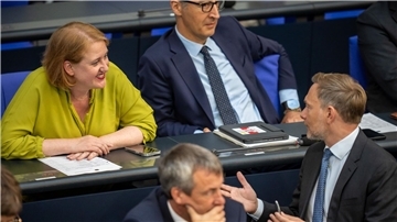 Finanzminister Christian Lindner (FDP) spricht im Bundestag mit Familienministerin Lisa Paus (Grüne).