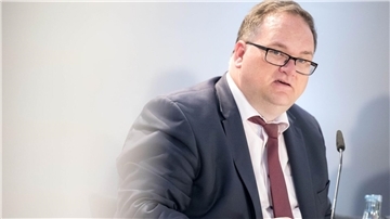 Mann vor einem Mikrofon. 