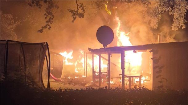Flammen schlagen aus einem brennenden Kleingartenhäuschen