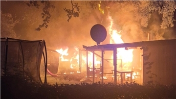 Flammen schlagen aus einem brennenden Kleingartenhäuschen