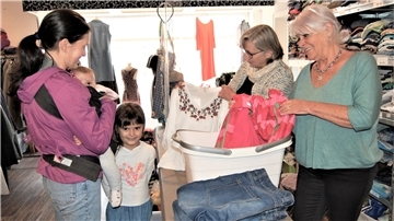 Florentina Tical kauft für sich und für ihre Kinder Sofia und Maia in der Kleiderkammer "Anziehungspunkt" ein. Von Gaby Kasper und Angelika Schlude bekommt sie eine ganze Tüte Kleidung für fünf Euro.