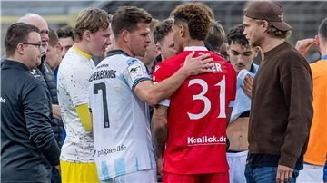 Florian Niederlechner (TSV 1860 München) spricht nach dem Rassismus-Vorfall aufmunternd mit Justin Butler (FC Energie Cottbus).
