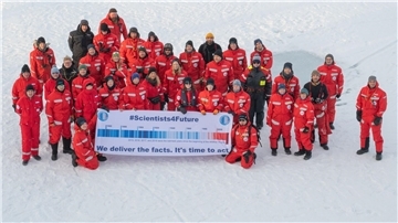 Forscher des Alfred Wegener Instituts mit einem Transparent mit der Aufschrift „#Scientists4Future - We deliver the facts. It’s time to act“ in der Arktis.