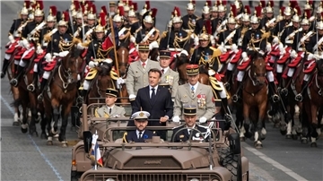 Frankreichs Präsident Emmanuel Macron in einem Kommandowagen mit General Thierry Burkhard, Chef des Generalstabes, bei der Parade auf der Avenue des Champs-Élysées. Frankreich erinnert an den Sturm auf die Bastille im Jahr 1789, der als symbolischer Beginn der Französischen Revolution angesehen wird.