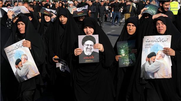 Trauerfeiern für Irans Präsident und Außenminister Frauen erinnern mit Plakaten an den verstorbenen Präsidenten.