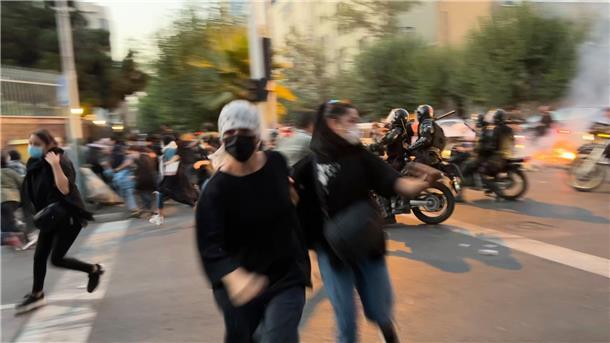 Proteste im Iran: Polizist greift Demonstrantin an den Po Frauen fliehen bei einem Protest in Teheran vor der Polizei.