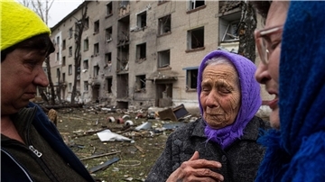 Frauen stehen in Lukiantsi in der Region Charkiw vor einem Haus, das durch einen russischen Luftangriff schwer beschädigt wurde.
