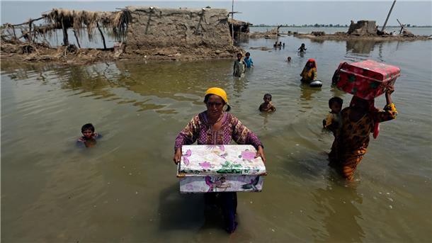 Unicef: Nach Flut fehlt Pakistanern sauberes Trinkwasser Frauen tragen Habseligkeiten aus ihrem durch heftige Regenfälle überschwemmten Haus im Bezirk Qambar Shahdadkot in der pakistanischen Provinz Sindh.
