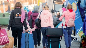 Frauen und Kinder aus der Ukraine sind mit Koffern unterwegs. Gerade werden Spenden für eine Ferienfreizeit für ukrainische Kinder gesammelt.