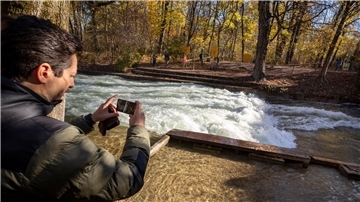 Freizeitsurfer Alexander Neumann fotografiert die - zurzeit nicht funktionstüchtige - Eisbachwelle im Englischen Garten.