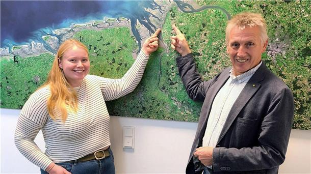 Junge Pächterin übernimmt den Nationalpark-Hof „Eide Icken“ Eine junge Frau und ein älterer Mann stehen vor einer Satellitenkarte der Nordseeküste und zeigen lächelnd auf einen Punkt in der Region Wurster Nordseeküste.