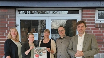 Drei Frauen und zwei Männer stehen vor dem Eingang der Turnhalle Einswarden. Die Nordenhamer Sportstätte wird bald energetisch saniert.