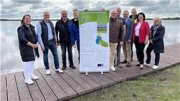 Freuen sich über den runderneuerten Steg am Bederkesaer See (von links): Wirtschaftsförderin Katja Beier, Ortsbürgermeister Thomas Kuberski, Thorsten Gerken vom Team Tiefbau der Stadt Geestland, Hauke Knust, Projektmanager bei der Stadt Cuxhaven, Jürgen von Ahnen von der Geschäftsstelle der LEADER-Region Wesermünde Nord, Sven Claussen von Bauplanung Nord, Lienhard Varoga vom Amt für regionale Landesentwicklung, Danny Staschen, Bauleiter bei der Firma Wübben, Bürgermeisterin Gabi Kasten und Alma 