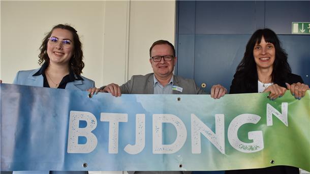 Frisch präsentiert hat die Butjadinger Tourismus-Servicegesellschaft beim Tourismustag in Tossens den neuen Butjadingen-Logo-Slogan: "BTJDNGN". Hier zeigen ein Banner (von links): Lyndzey Mowatt, Geschäftsführer Claudio Patrik Schrock-Optiz und Henrike Backhaus-Windels.