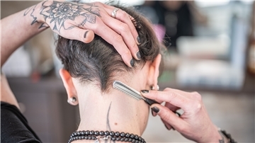 Friseurin Manuela Pickruhn rasiert die Konturen im Nacken mit einem "Razor".