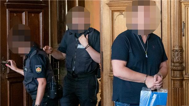 Ein Mann betritt in Handschellen den Gerichtssaal. 