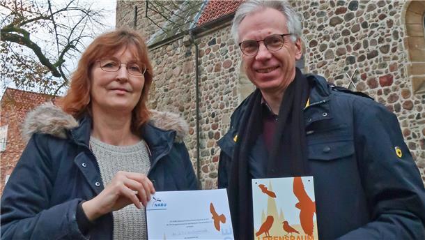 Für besonderen Einsatz im Artenschutz erhält Pastor Martin Knapmeyer, stellvertretend für die St.-Viti-Gemeinde, von Bettina Schroeder (NABU) die Auszeichnung „Lebensraum Kirchturm“.
