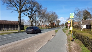 Ein Auto fährt über eine Landstraße.