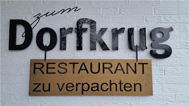 „Restaurant zu verpachten“ steht auf einem Schild, das vor einem Haus steht. Für den Dorfkrug in Lunestedt wird ein neuer Pächter gesucht. 