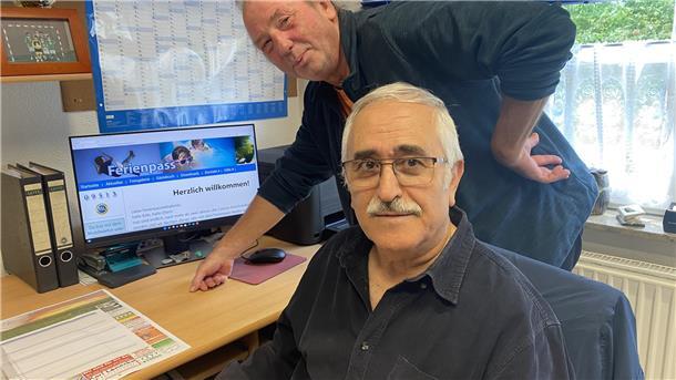 Zwei Männer stehen vor einem Computer