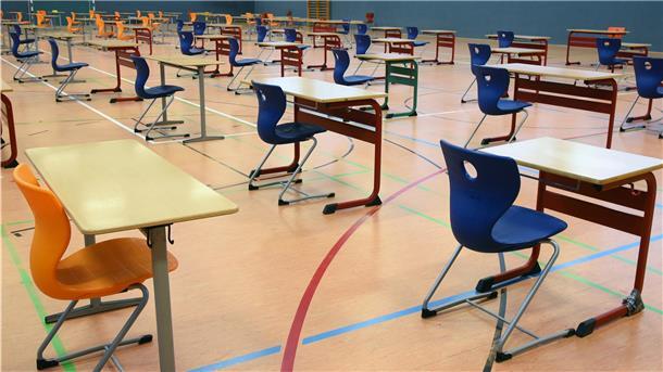 Mit großen Abständen stehen Tische und Stühle in der Turnhalle vom Montessori-Schulzentrum in Leipzig.