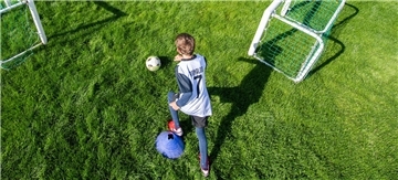 Gemeinde Heeslingen unterstützt die Arbeit der Vereine mit der Jugend Ein Junge spielt auf dem Rasen Fußball.