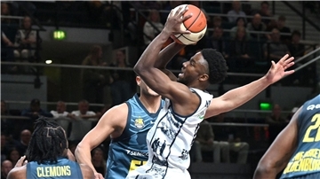 Ein Basketballer zieht zum Korb und wirft.