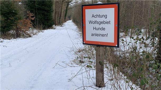 Ein Schild ist an einem verschneiten Weg zu sehen.