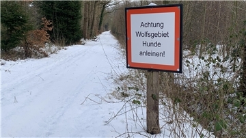 Ein Schild ist an einem verschneiten Weg zu sehen.