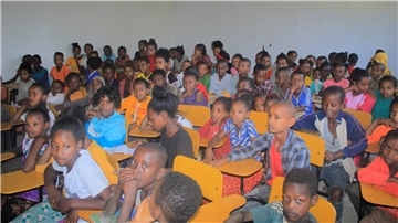 Kinder sitzen in einem Klassenraum zusammen. 