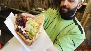 Galip vom Imren Grill in Berlin bereitet einen Döner zu.