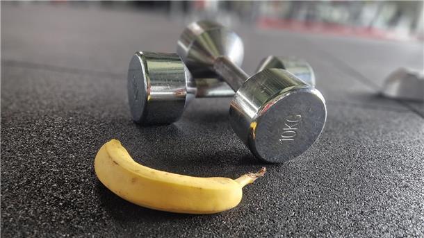 Bananen-Power: Dein schneller Energiekick vor dem Sport Eine Banane neben Hanteln.