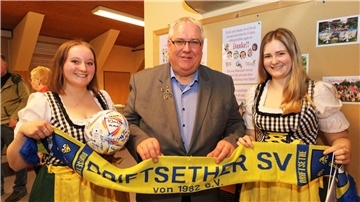 Gemeinsam mit den „Deerns“ der Landjugend freut sich Vorsitzender Hartmut Wendelken über das gelungene Fußballspiel gegen Lehnstedt. Ein Ball mit Unterschriften soll daran erinnern.