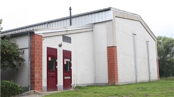 Weißes Haus mit dunkelroten Türen